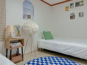 ソウルにあるBlue Houseのベッドルーム1室(ベッド2台、ランプ付きテーブル付)