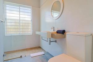 un baño con lavabo y espejo en Lily House, en Bettyʼs Bay