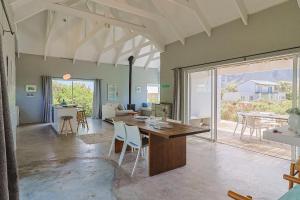 Una gran sala de estar con mesa y sillas. en Lily House, en Bettyʼs Bay