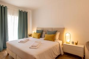 a bedroom with a large white bed with yellow pillows at Luxuosa Villa com Piscina, Garagem e Vista Mar in Tavira +36 photos