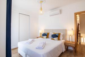 a bedroom with a white bed with two towels on it at Luxuosa Villa com Piscina, Garagem e Vista Mar in Tavira