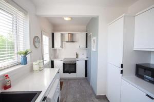 una cucina con mobili bianchi e una stufa di Beautifully Designed Pollok House a Glasgow