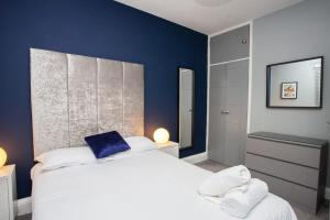 una camera con un letto bianco e una parete blu di Beautifully Designed Pollok House a Glasgow