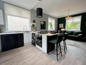 una cocina con fregadero y estufa horno superior en Loch Lomond Mews, en Balloch 11 fotos más