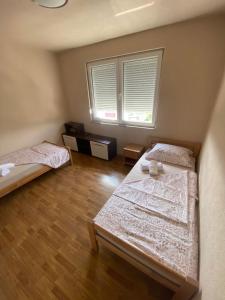 a bedroom with two beds and a window at Apartman BM2 in Posušje +2 photos