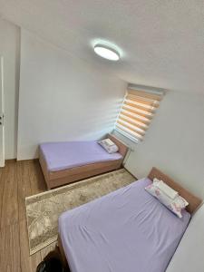una piccola stanza con due letti e una finestra di Room Ejna 1 a Sarajevo