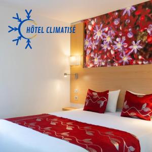 a hotel climate room with a bed with red pillows at Fasthotel Orleans Zénith in Orléans