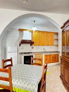 a kitchen with a table and a white refrigerator at Casa Josefina in Sant'Angelo D'Ischia +14 photos