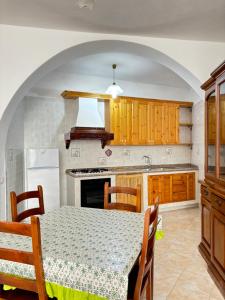 a kitchen with a table and a kitchen with a refrigerator at Casa Josefina in Sant'Angelo D'Ischia