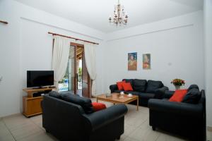 uma sala de estar com dois sofás e uma televisão em Amalia Villa em Pólis