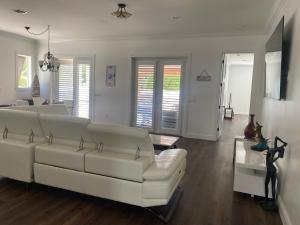 a living room with a white couch and a table at Paradise Pool House in Dania in Dania Beach