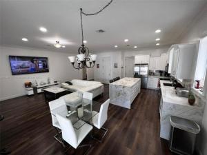 a large kitchen and living room with white furniture at Paradise Pool House in Dania in Dania Beach