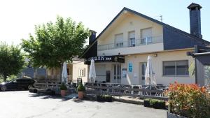a building with a car parked in front of it at Pensión Albergue Gonzar in Portomarin