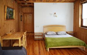 a bedroom with a bed and a wooden table at Girskiy Prutets in Bukovel