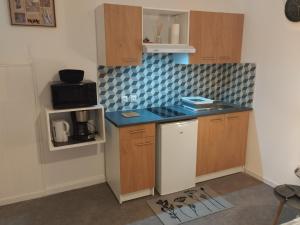 a small kitchen with wooden cabinets and a blue counter top at résidence bregeroise 5 in Limoges
