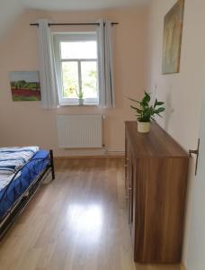 a bedroom with a bed and a dresser and a window at Fewo David und Marion oben, nahe der Nordsee und dem Weser Radweg in Golzwarderwurp