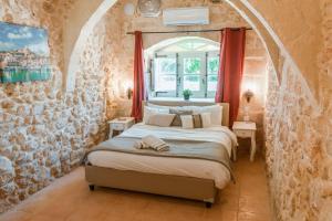シャーラにあるVilla Oliva 4 bedroom villaの石の壁の中にベッドが置かれた寝室 +16枚の写真