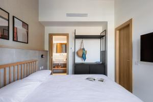 a bedroom with a white bed and a bathroom at Tayo Studios & Apartments in Bat Yam