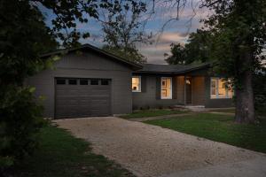 a house with a garage and a driveway at The Olive Branch - Hot Tub & Walk to Main in Fredericksburg