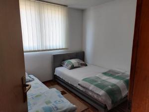 a small bedroom with a bed and a window at Apartman Leki in Sarajevo