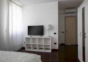 a bedroom with a television on a white cabinet at la foglia verde in Pesaro