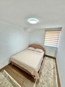 una piccola camera da letto con un letto e una finestra di Room Ejna 2 a Sarajevo