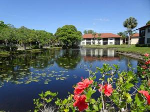 a pond in a park with red flowers at Florida Bella Rosa near IMG Academy & beaches in Bradenton +47 photos