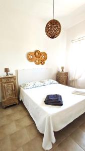 a bedroom with a large white bed and a chandelier at Casa del Pescatore in Nardò