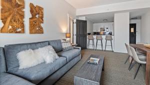 a living room with a gray couch and a table at 351 Lodge At Spruce Peak Ski In Ski Out 3 Bedroom Suite By Stowe Mountain Rentals in Stowe +20 photos
