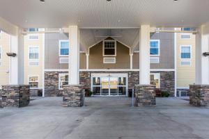 a large building with pillars in front of it at MainStay Suites Sidney - Medical Center in Sidney