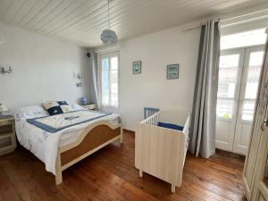 ein Schlafzimmer mit einem Bett und einem Kinderbett in der Unterkunft Ker Lucette in Saint-Gilles-Croix-de-Vie