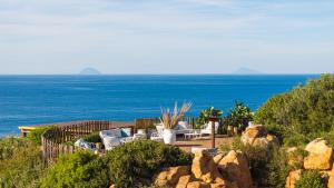a patio with a view of the ocean at Mangia's Pollina Resort in Cefalù
