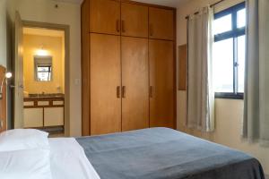 レゼンデにあるHotel Vila Rica Flatのベッドルーム1室(ベッド1台、木製キャビネット、シンク付)