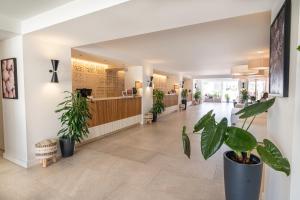 a hallway with potted plants in a lobby at Mangia's Pollina Resort in Cefalù