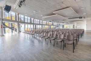 a large room with rows of chairs in a building at Mangia's Pollina Resort in Cefalù