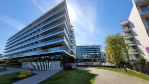 duży budynek biurowy z parkiem przed nim w obiekcie Seaside Park Resort w Kołobrzegu