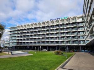 duży budynek z trawnikiem przed nim w obiekcie Seaside Park Resort w Kołobrzegu