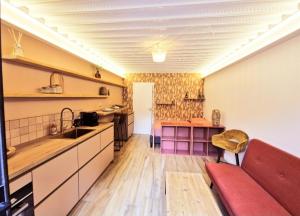 a kitchen with a red couch in a room at Maison Juliette in Clichy