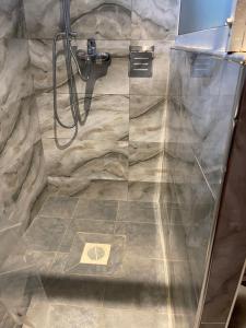 a bathroom with a shower with a glass door at BAZY SUITEs in Kampala