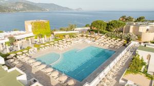 an aerial view of a resort with a pool and chairs at Mangia's Pollina Resort in Cefalù