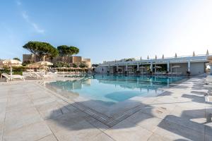 a swimming pool in a resort with trees and a building at Mangia's Pollina Resort in Cefalù