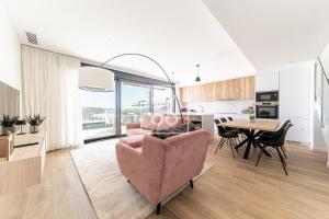 un salon avec une chaise rose et une table dans l'établissement FineFleur Finestrat - see and mountain views - by OYOOSTAYS, à Finestrat