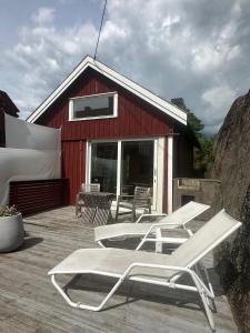 a group of lounge chairs on the deck of a red building at Guest House in Tjøme