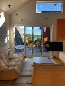 a living room with a couch and a television at Guest House in Tjøme