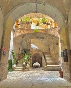 un bâtiment en pierre avec un escalier avec des plantes en pot dans l'établissement Heraklean Suites Tropea, à Tropea