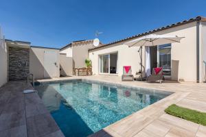 a swimming pool in the backyard of a house at Villa Mery in Béziers