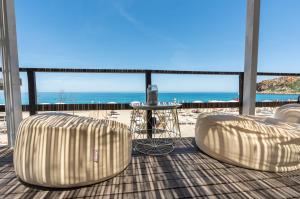 a balcony with two chairs and a table and the beach at Mangia's Pollina Resort in Cefalù