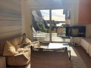 a living room with a couch and a large window at Guest House in Tjøme +19 photos