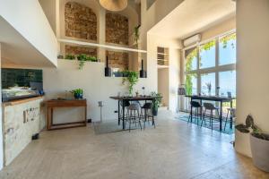 a large kitchen with tables and chairs and windows at Mangia's Pollina Resort in Cefalù