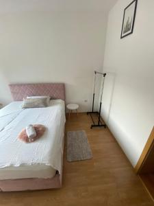 a bedroom with a pink bed with a pink headboard at Apartman MB in Posušje